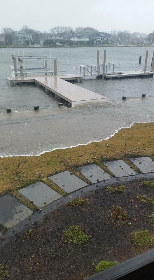 Coastal flooding has the water creeping up over the lawn of this home in Avon, NJ along the Shark River.  Photo credit: Kathy Innocenti
