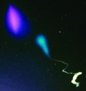 The cloud in the upper left hand part of the image is due to a barium release. The purple-red part is the ionized component which has become elongated along the Earth’s magnetic field lines. The purple-blue cloud that surrounds the red ionized barium is a combination of the neutral barium and strontium. The blue and white trail in the lower portion of the image is from a TMA vapor trail that reveals the neutral wind trails as a function of altitude. Credits: NASA