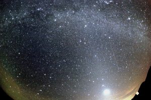 An Orionid meteor (center right) streaking across the sky below the Milky Way and to the right of Venus. Image: Wikipedia