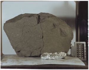 Lunar Sample 70215 was retrieved from the Moon’s surface and returned by NASA's Apollo 17 crew. The sample is a basaltic lava rock similar to lava found in Hawaii. It crystallized 3.84 billion years ago when lava flowed from the Camelot Crater. Sliced off a parent rock that originally weighed 8,110 grams, the sample weighs 14 grams, and is very fine grained, dense and tough. Photograph: NASA
