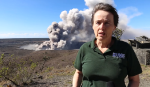 Tina Neal stands near the USGS Hawaii Volcanoes Observatory as ash rises from the Kilauea caldera behind her. Image: USGS