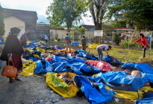 People look for tsunami and earthquake victims in body bags at a police station in Palu, Indonesia today. Image: EPA-EFE