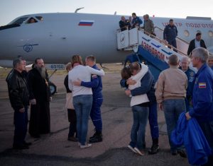 Astronaut Nick Hague, right, and cosmonaut Alexey Ovchinin, left, embrace their families after landing in Baikonur, Kazakhstan. Hague and Ovchinin arrived after a safe landing on Earth following a Soyuz booster failure during launch earlier. Image: NASA