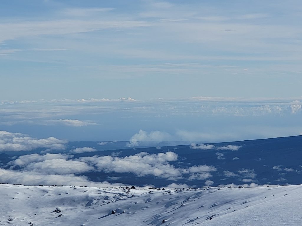 Fire and ice! The puff of clouds/smoke in the very middle of this picture is actually steam and smoke rising from the ongoing volcanic eruption at Kilauea. The volcano can be viewed from the summit of Mauna Kea here today. Image: Weatherboy