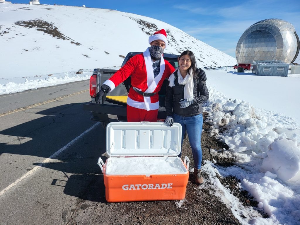 Identified only as Reed and as Carrie, these two people from the Big Island of Hawaii drove up to the summit of Mauna Kea once roads were plowed and open today to load up a cooler with snow. Their plan is to bring it to a friend's house in Kona to have a snowball fight. Image: Weatherboy