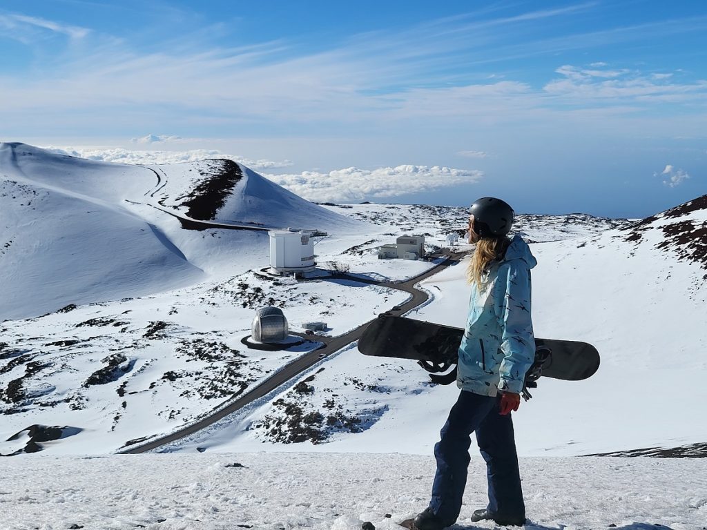 Snowboarder Quinn Weaver from Kalapana on Hawaii Island's east coast, surveys the slopes of Mauna Kea before gliding down the snow-covered volcanic landscape on his snowboard. Image: Weatherboy