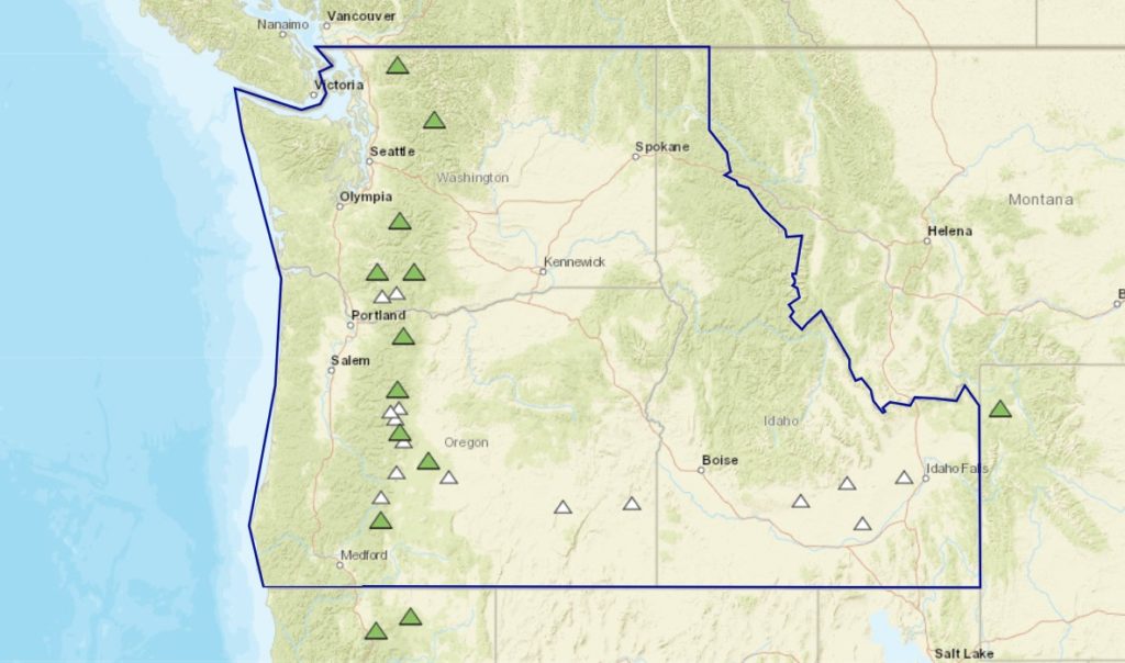 The Cascades Volcano Observatory tracks activity at volcanoes throughout the region within the solid blue line. Each tracked volcano is indicated by a triangle, with volcanoes at "GREEN" status in green and those with no declared status in white. Image: CVO/USGS