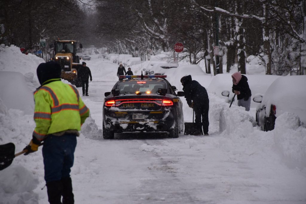 Troopers in Buffalo are seen here assisting road clearing crews and checking for stranded motorists in Buffalo, New York in the wake of the pre-Christmas Bomb Cyclone. Image: New York State Police