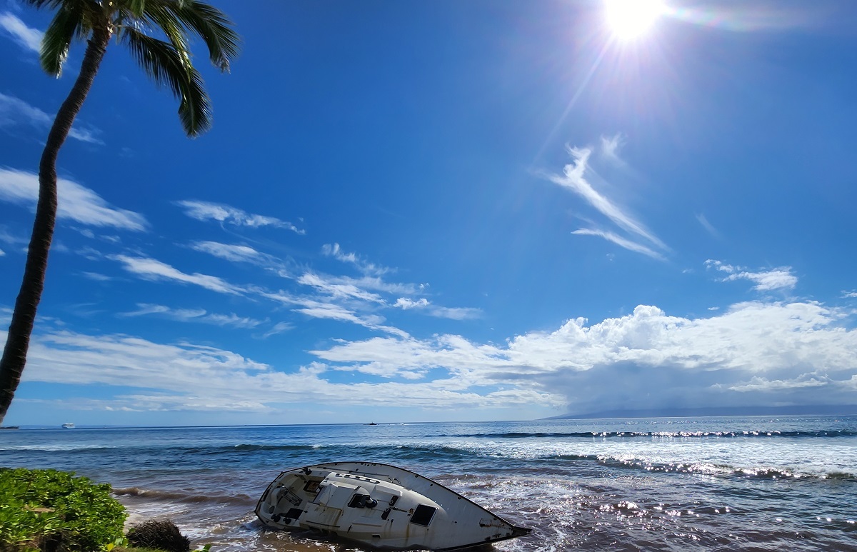 An abandonned sail boat and surf up to a vegetation line is all that remains in front of the Marriott Maui Ocean Club on Kaanapali Beach, Maui in this photograph taken in October 2022. Image: Weatherboy