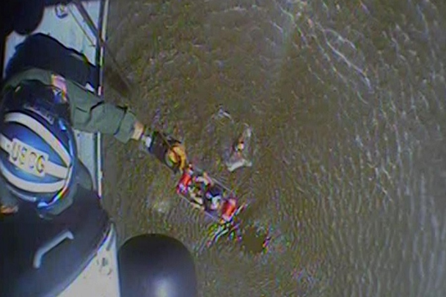 A still photo taken from video of the crew of an MH-60 Jayhawk at Coast Guard Air Station New Orleans rescuing a crew member from a capsized boat off Slidell, Louisiana, on September 18, 2022. The crew and their dog were safely rescued and transported to a nearby dock.Image: US Coast Guard