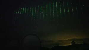 A row of bright green laser flashes light up the night sky over Mauna Kea on Hawaii's Big Island. Image: National Observatory of Japan
