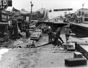 Fourth Avenue near C Street in Anchorage , Alaska shows the aftermath of the 1964 seismic event which left parts of the city 11-14 feet flower than other parts, tearing apart buildings and tossing cars and trucks up and down like toys. Image: U.S. Army
