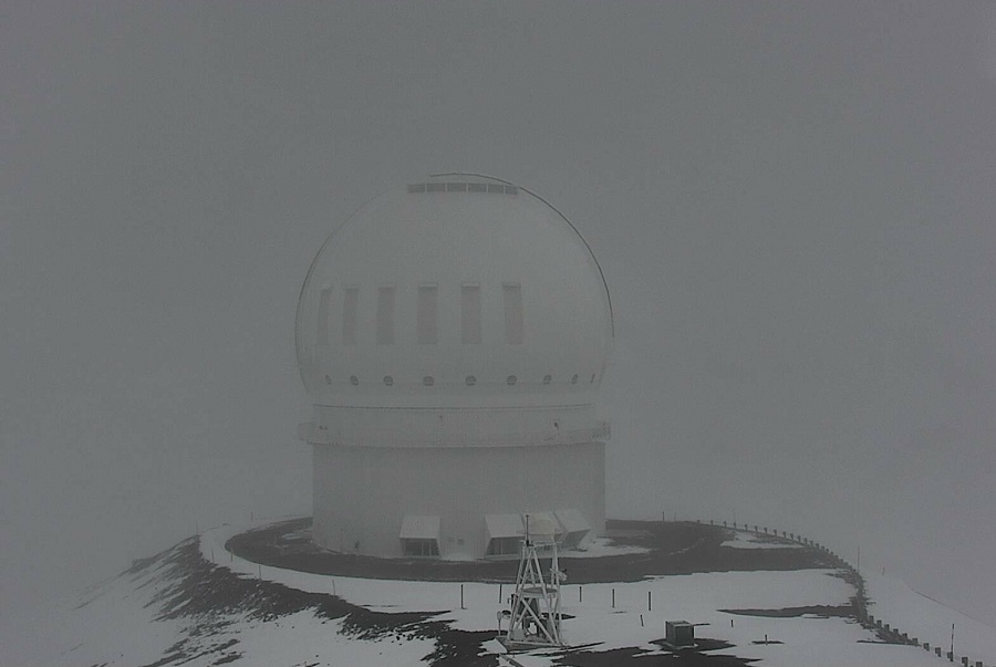 Current webcam view of the Canada France Hawaii Telescope shows snow falling and accumulating on Mauna Kea in Hawaii. Image: Center for Maunakea Stewardship / University of Hawaii