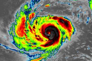 The latest color-enhanced satellite photograph of Typhoon Mawar shows an intense tropical cyclone heading to Guam, which is outlined in hot-pink to the north and west of the center of the typhoon. Image: NOAA