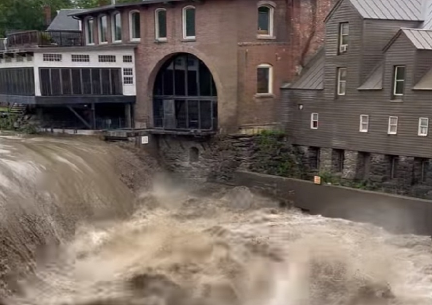 Floodwaters are pouring over the dam this morning on the Ottauquechee River near Simon Pearce in Quechee, Vermont. Image: Vermont State Police