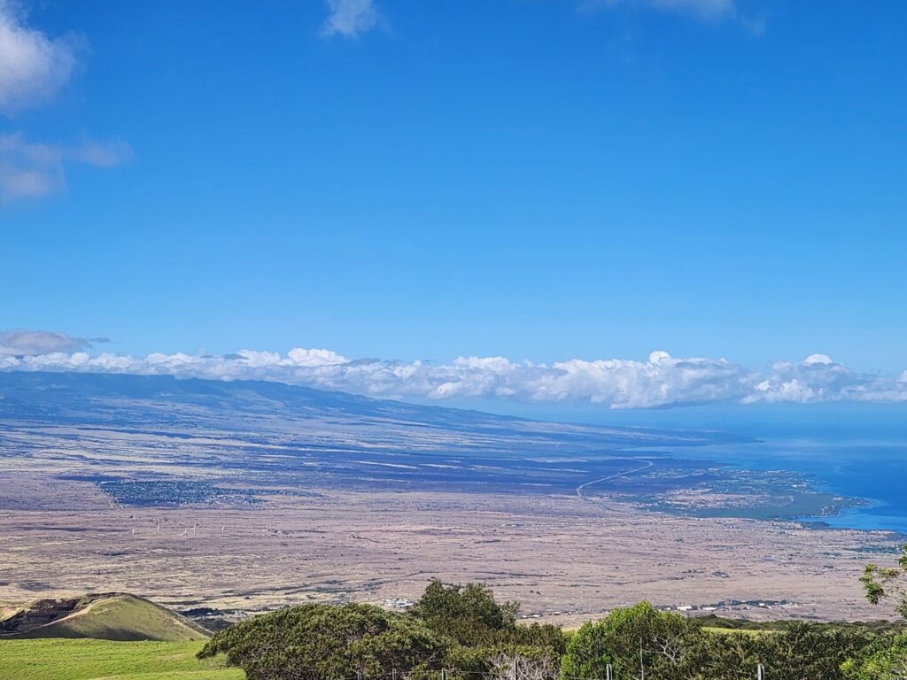 This view from Kohala Mountain on the Big Island of Hawaii shows Waikoloa Village, left, and the Waikoloa Beach resort at the coast, on the right. Potentially damaging winds are possible here tonight into Tuesday. Additionally, there's a significant wildfire risk in this area, as shown by how dry vegetation is in this region. Photograph captured on August 5, 2023. Image: Weatherboy