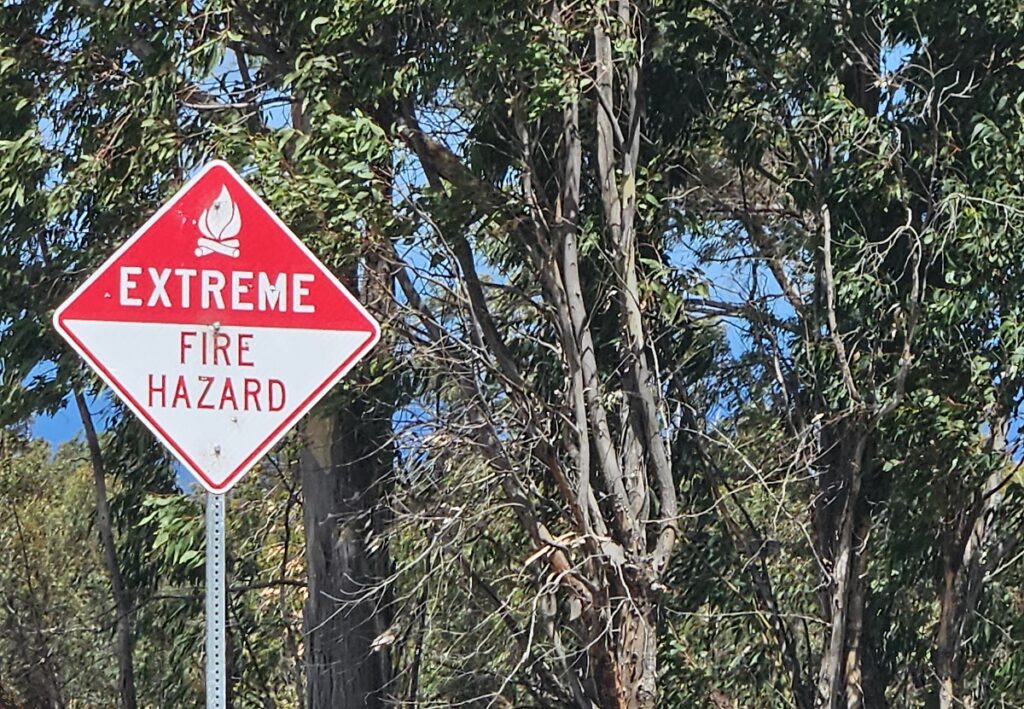 A sign outside of Waikoloa Village on the Big Island of Hawaii warns of a nearly always-present fire hazard there due to flammable invasive vegetation that surrounds the community on the leeward / downwind side of the island. Image: Weatherboy
