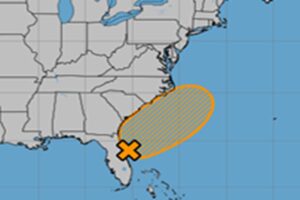 The National Hurricane Center says it is now more likely than not that a system will form near the X and move around in the orange shaded area on this map over the holiday weekend. Image: NHC