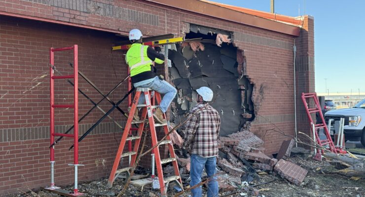 Workers inspect and make initial repairs on a National Weather Service office where a vehicle penetrated the building. Image: NWS